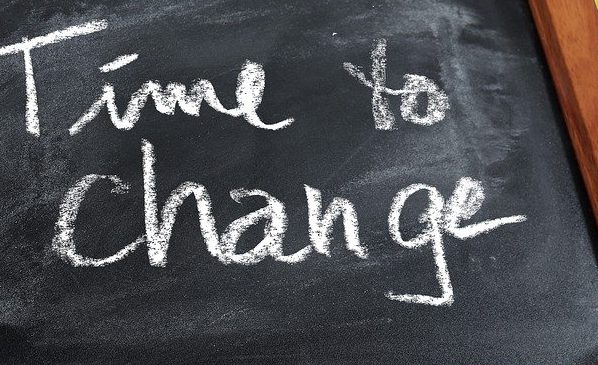 Text auf einer Tafel: "Time to change" in weißer Schrift auf schwarzem Hintergrund.